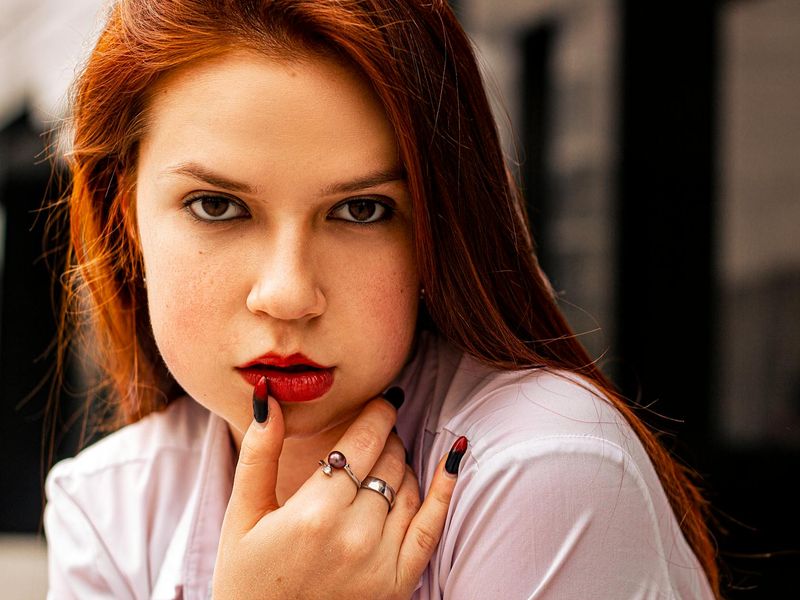 A close-up shot of a man's hands in a plank position on a dark floor.